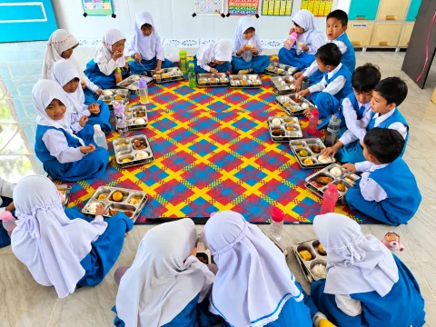 Kebersamaan anak-anak saat menikmati makanan.